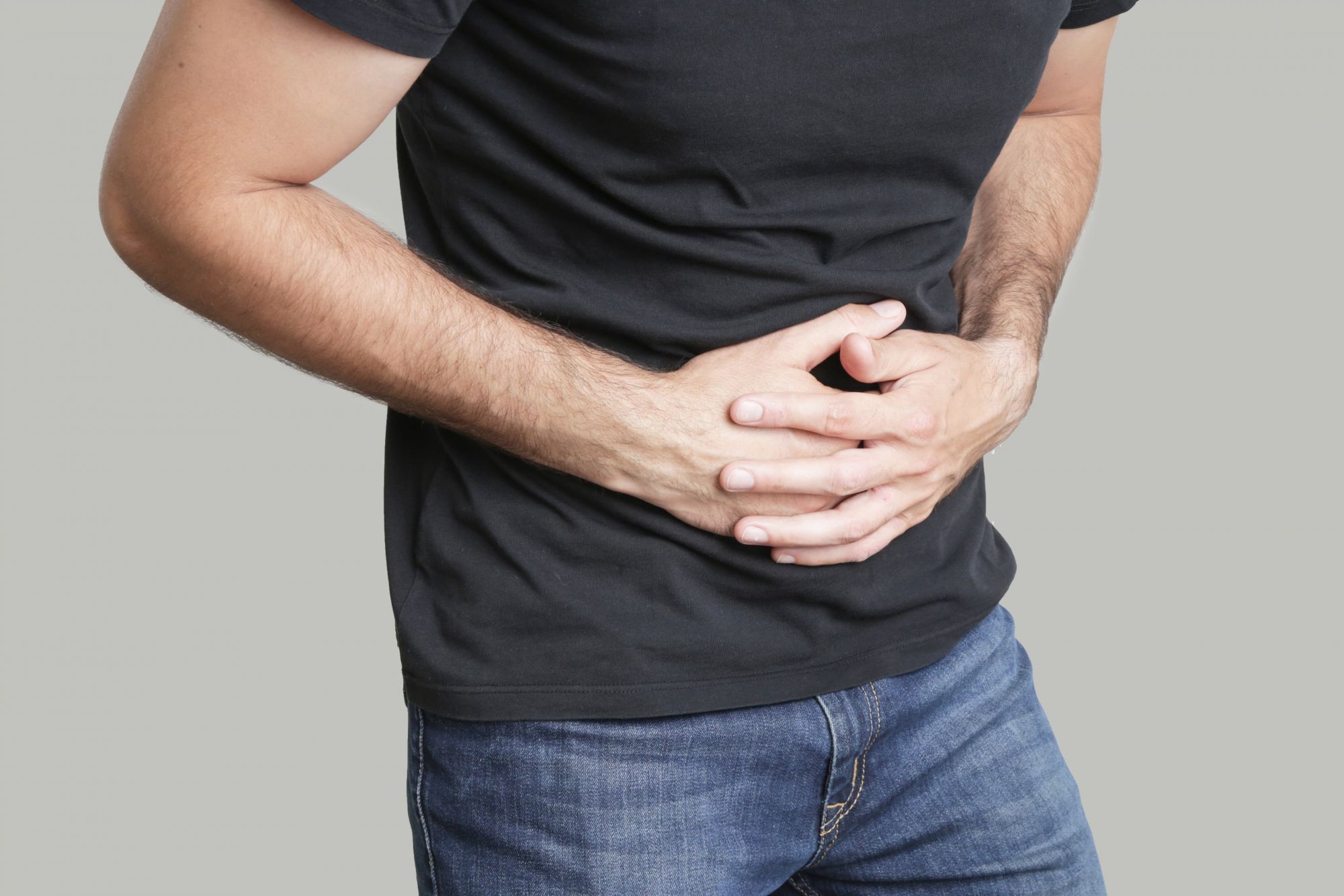 A man with chronic pelvic pain syndrome clutching his stomach.